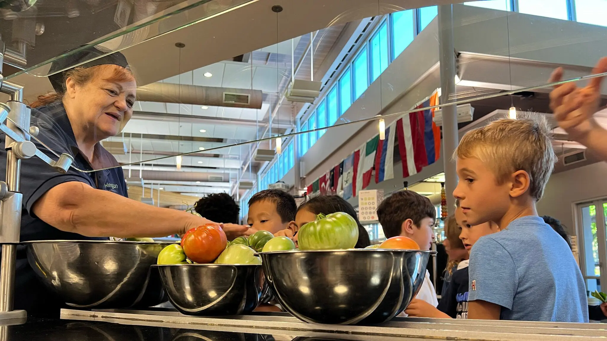 Student standing with staff at lunch line